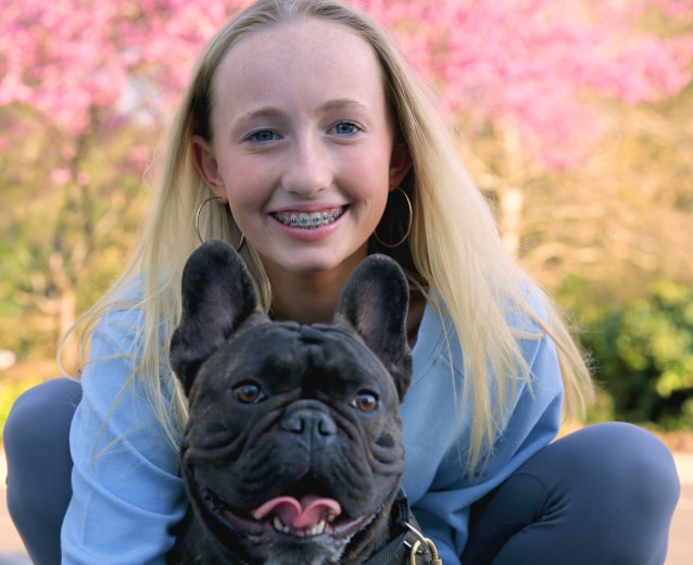 girl with dog and braces Queen City Smiles Orthodontics in Charlotte, NC